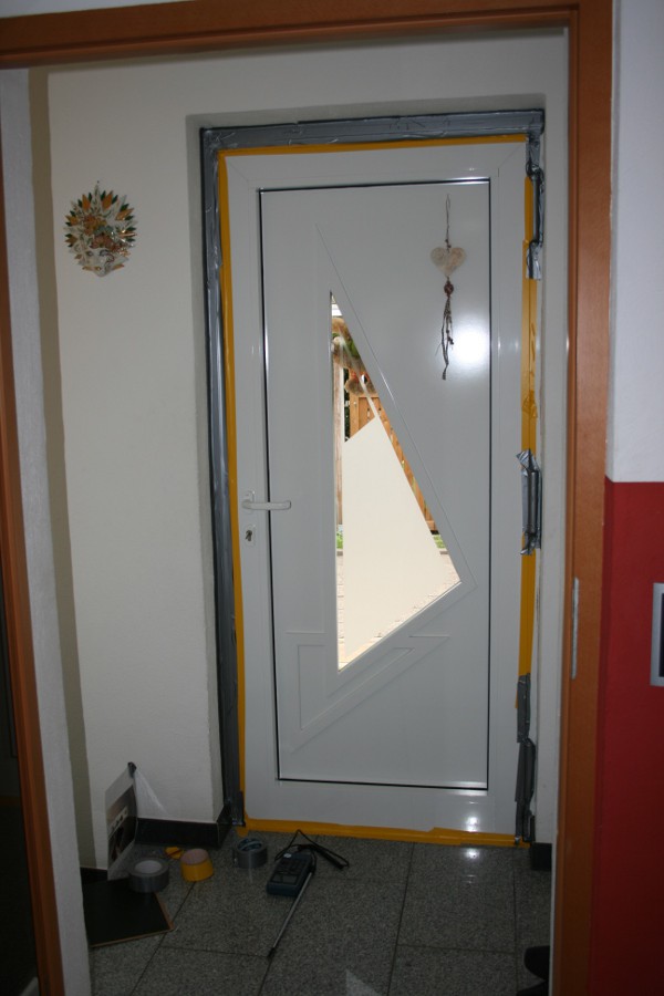 Abklebung der Schließfuge einer Eingangstür bei einer Leckagesuche